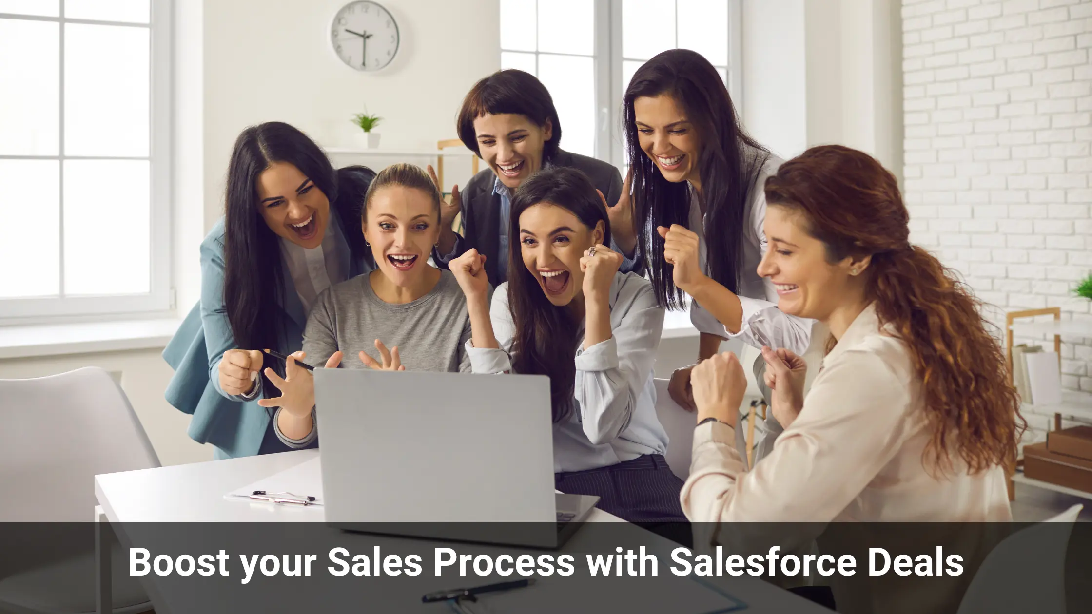 A group of women employees celebrating with their hands up while looking at a laptop.